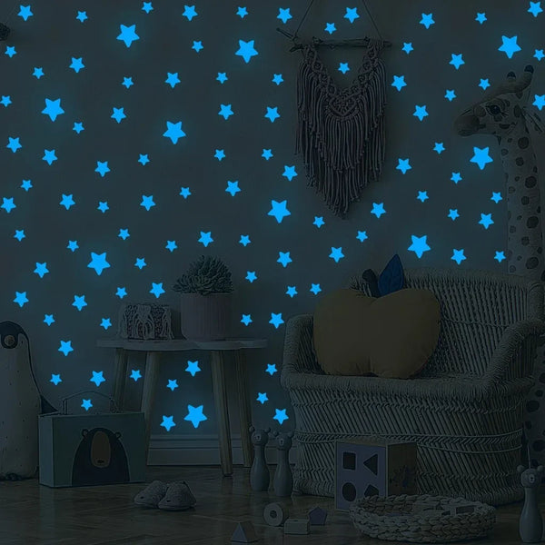 Un mur gris décoré d'autocollants d'étoiles luminescentes bleues et d'une peluche de girafe