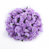 Un amas dense de petites fleurs d'hydrangea artificielles dans des tons de violet et lavande.