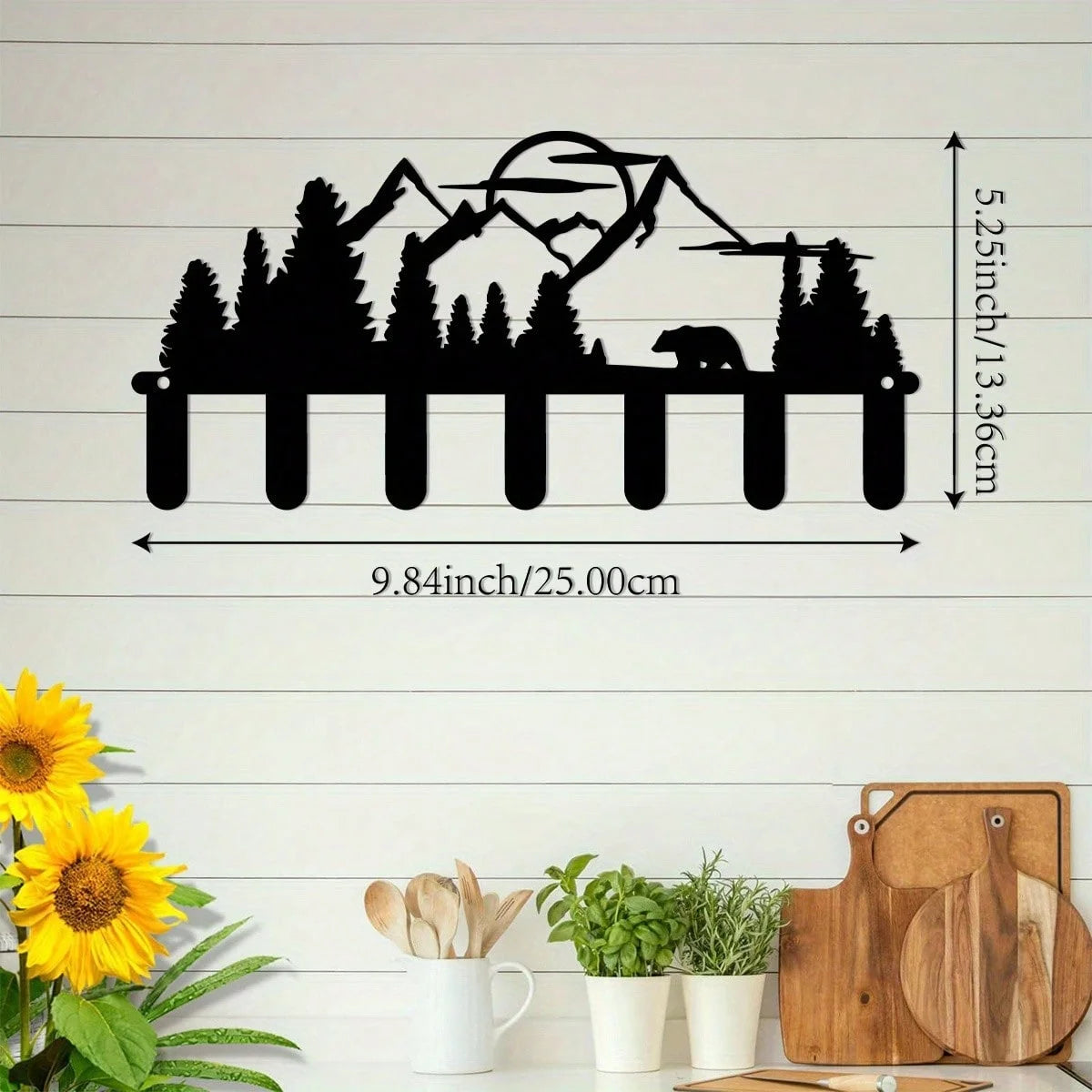 Black silhouette of an industrial iron wall mount key holder with seven hooks against a white wooden background.