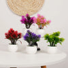 Collection de mini-bonsaïs artificiels décoratifs violets et roses sur une table blanche.
