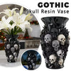 Un vase en résine noire rempli de décorations crânes, au design gothique.