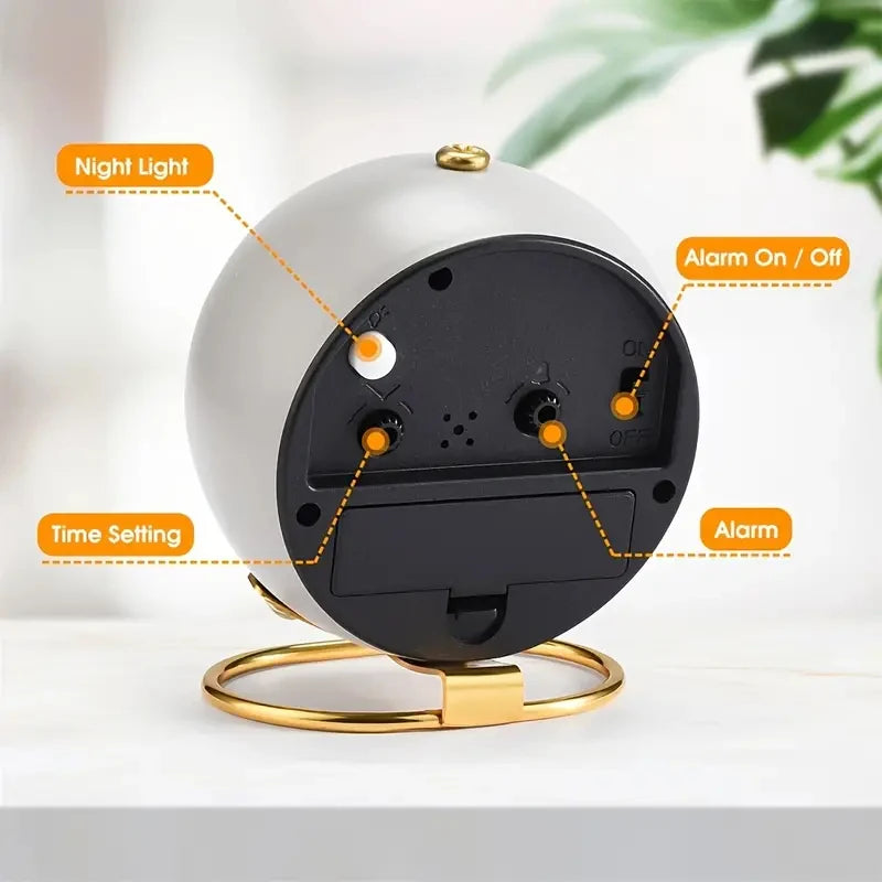 A white minimalist alarm clock with a black face and gold accents, showing features like night light and alarm settings.