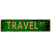 A rectangular green metal tin sign with the text TRAVEL ST in gold lettering.