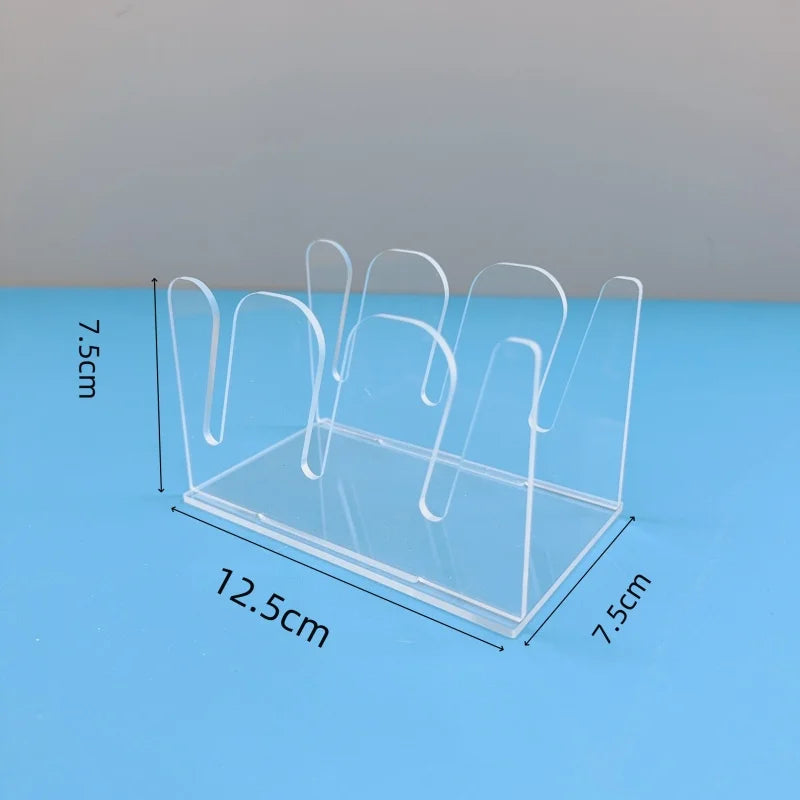 Clear acrylic hat storage rack with multiple hooks displayed on a blue surface.