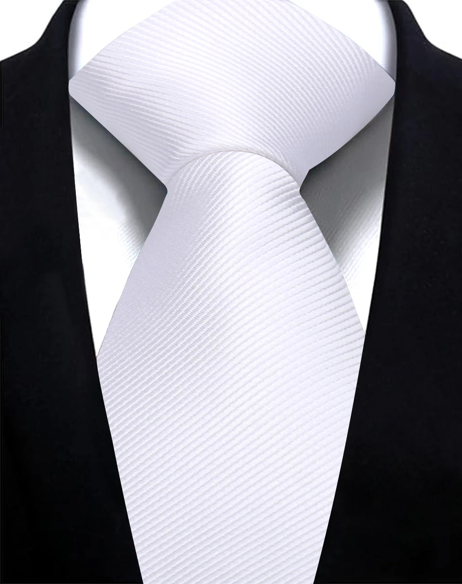 A close-up of a white silk necktie tied in a simple knot against a black suit jacket.