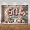 A pink and gold balloon backdrop for a 60th birthday celebration featuring balloons, flowers, and a large number 60.