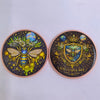 A pair of gothic copper challenge coins featuring exclusive bee designs with celestial elements.
