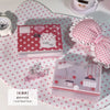 Una caja de almacenamiento minimalista rosa con temática de ensueño para pegatinas y tarjetas, mostrada sobre un paño de luna