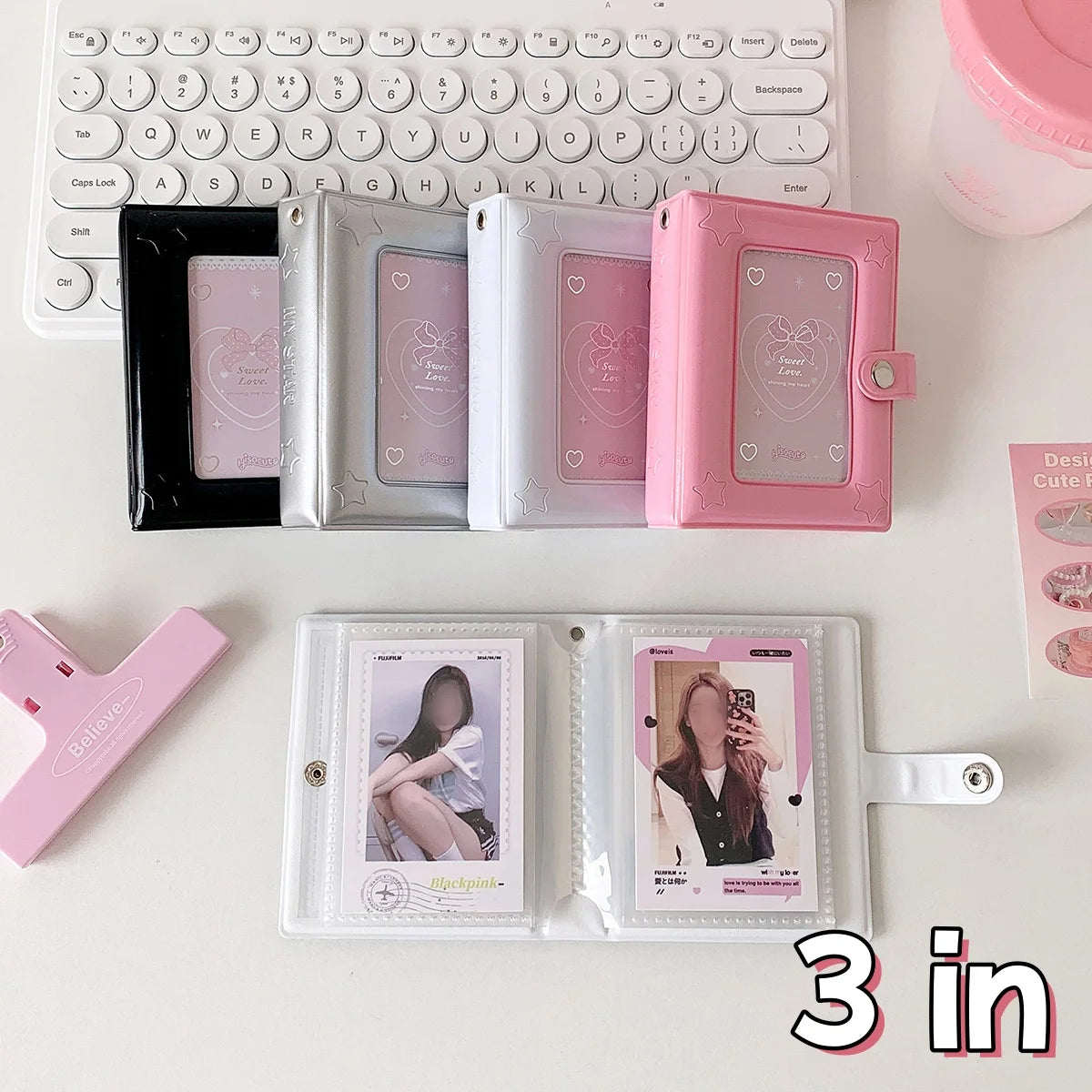 A set of pink and silver mini photo card binders and a black binder displayed on a white surface.
