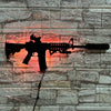 A black gun-shaped LED light mounted on a stone wall, illuminated with an orange glow.