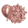 A pile of metallic rose gold latex balloons scattered on a white background.