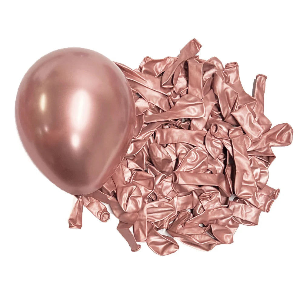 A pile of metallic rose gold latex balloons scattered on a white background.