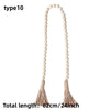 Beaded wall hanging with a long, arched shape and tassels in a natural beige color.