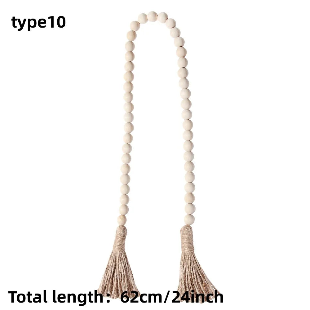 Beaded wall hanging with a long, arched shape and tassels in a natural beige color.