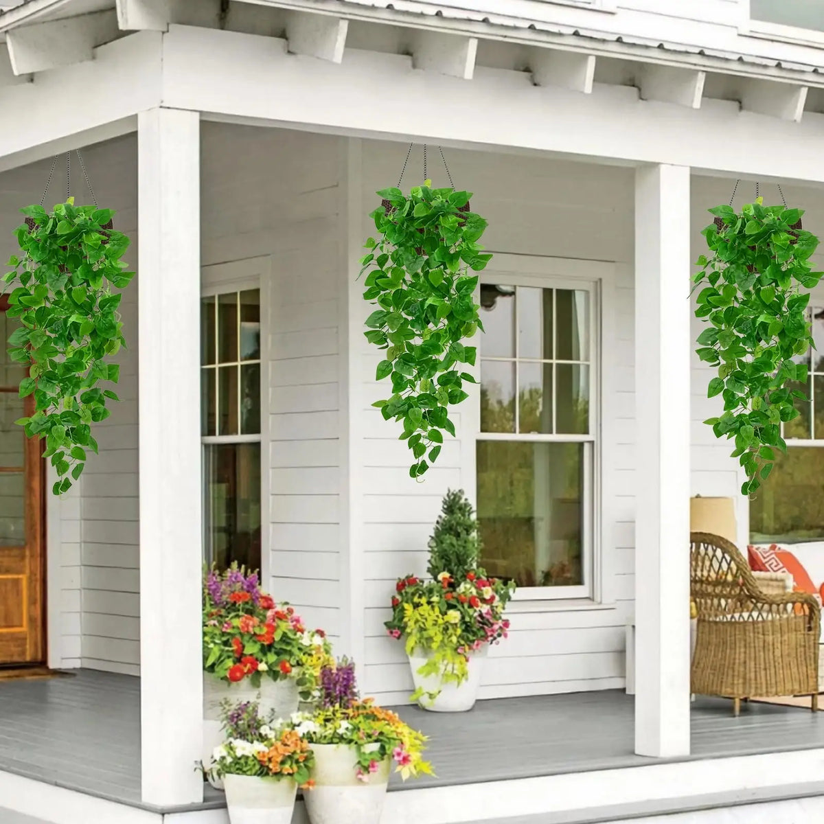 Artificial pothos hanging vines in green cascading from a window box on a white porch