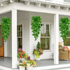 Artificial pothos hanging vines in green cascading from a window box on a porch