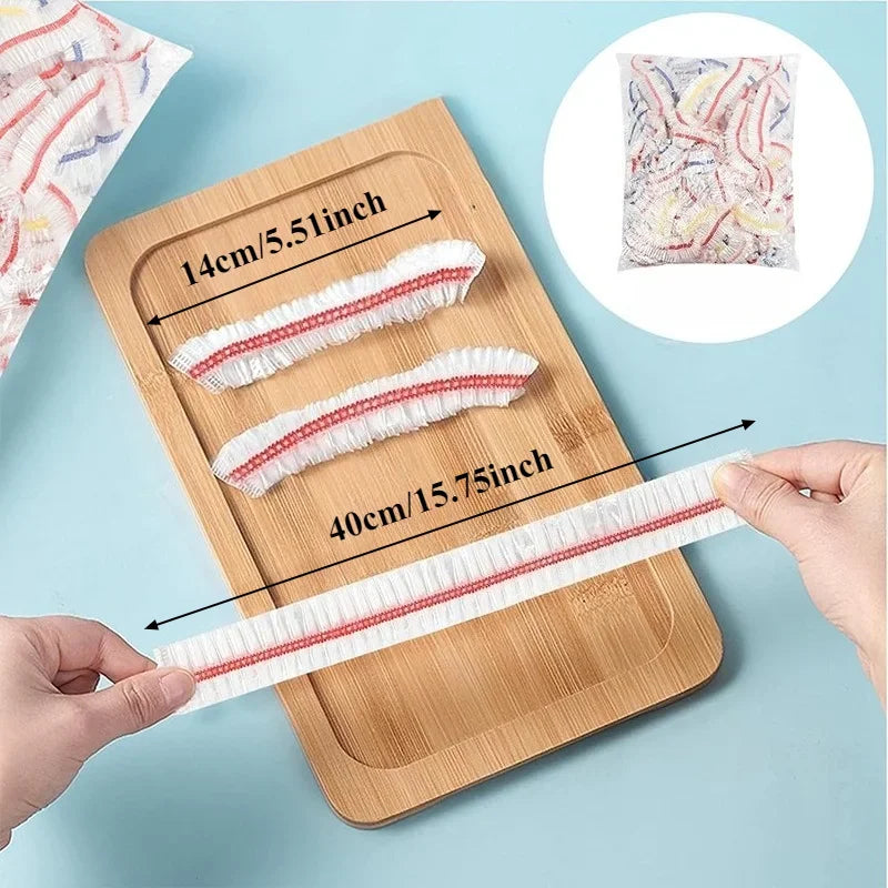 Reusable clear cling film strips of varying widths displayed on a wooden cutting board.