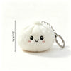 A white plush butter dumpling squishy keychain with a smiling face and silver keyring.