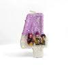 A purple glitter candle featuring three character figurines on a white wax base.
