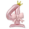A pink foil balloon shaped like the number four with a gold crown topper