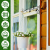 A white planter with flowers hangs from a vintage black iron wall hook mounted on a window frame.