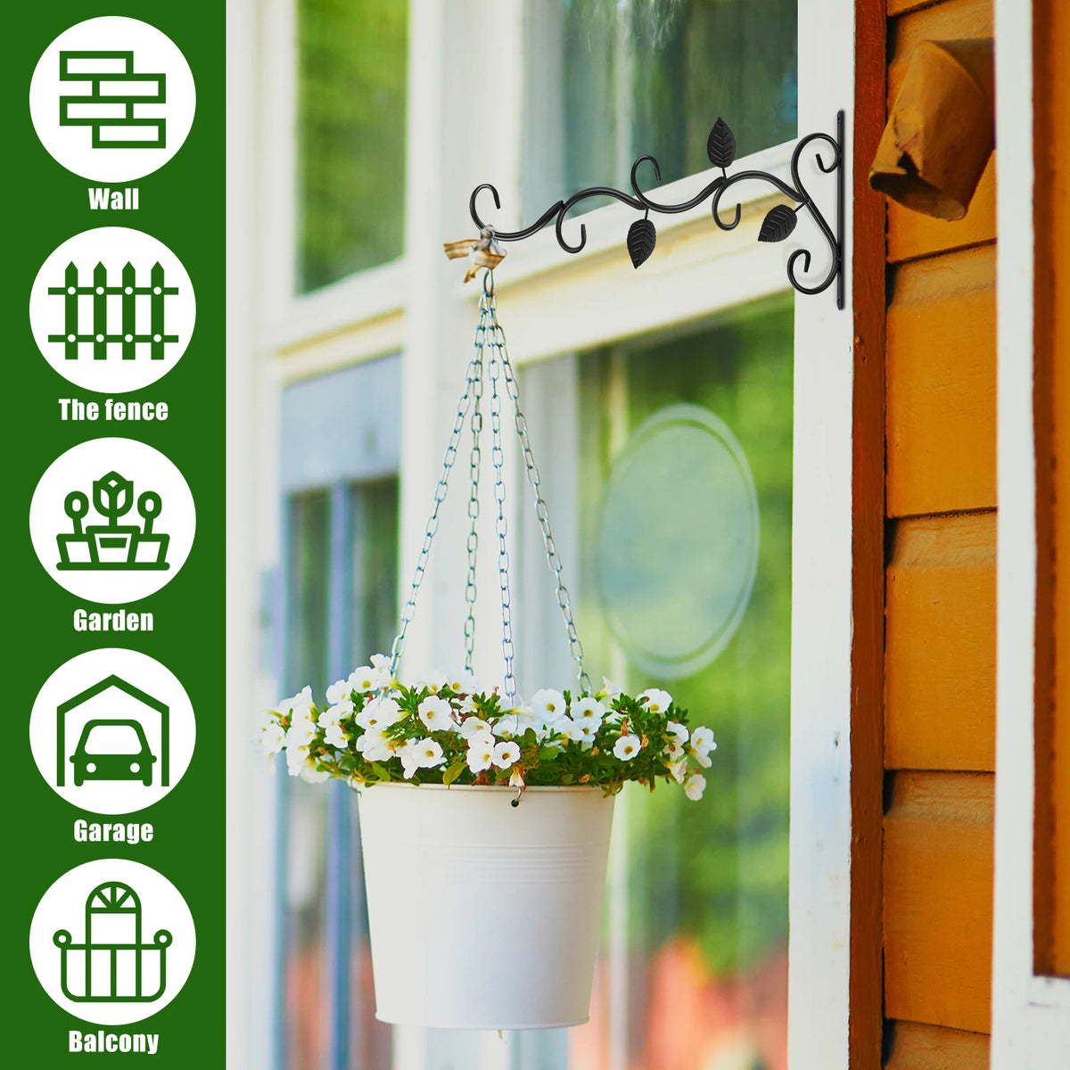 A white planter with flowers hangs from a vintage black iron wall hook mounted on a window frame.