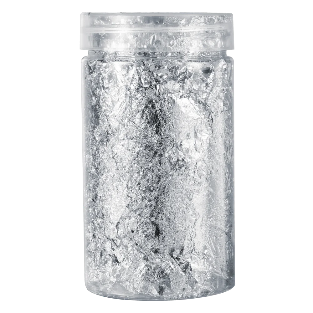 A clear glass jar filled with shiny gold foil flakes for resin art and jewelry making