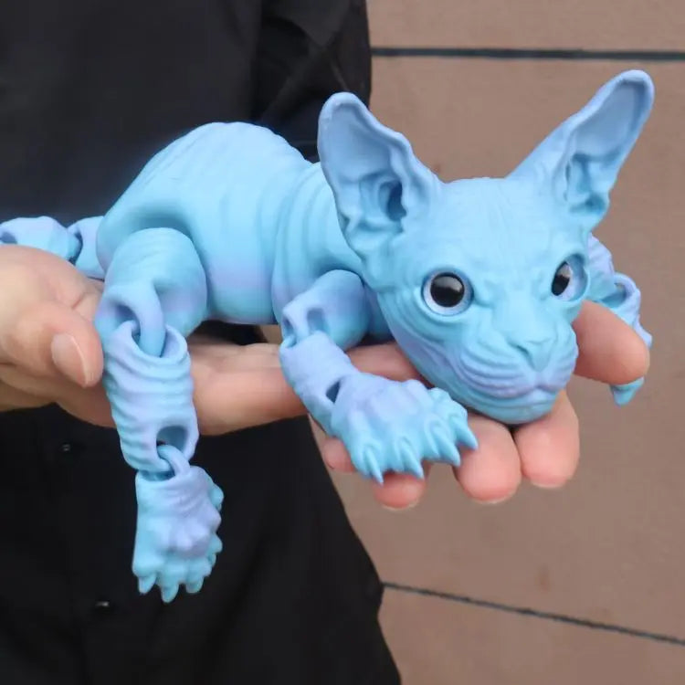 A hand holds a realistic light blue Sphynx cat fidget toy with wrinkled skin and large ears.