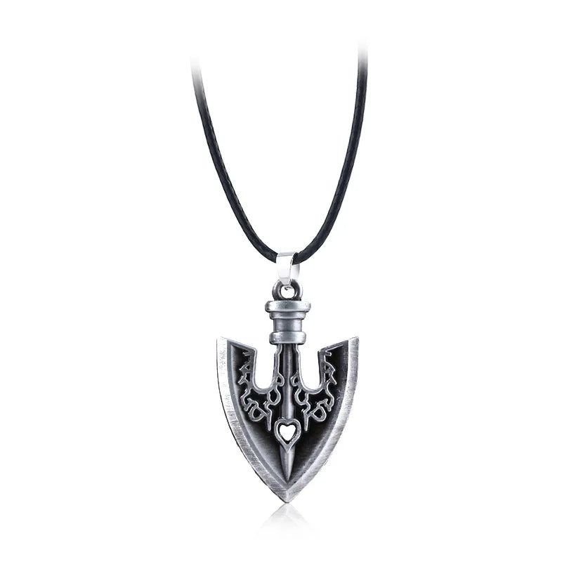 Silver arrow metal keychain with a decorative design hanging from a black cord