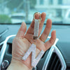 A hand holds a crystal letter keychain charm shaped like the letter N.