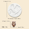 A white silicone mold featuring an owl, a witch's hat, and a broomstick for Halloween baking.