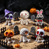 A collection of Halloween resin figurines featuring skeletons, mummies, and rabbits set in a dirt landscape.