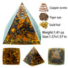 A pyramid-shaped crystal display featuring a copper screw, tiger eye, and gold foil crystals.
