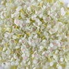 A close-up view of silk artificial flower heads in pale green and white with pink accents.