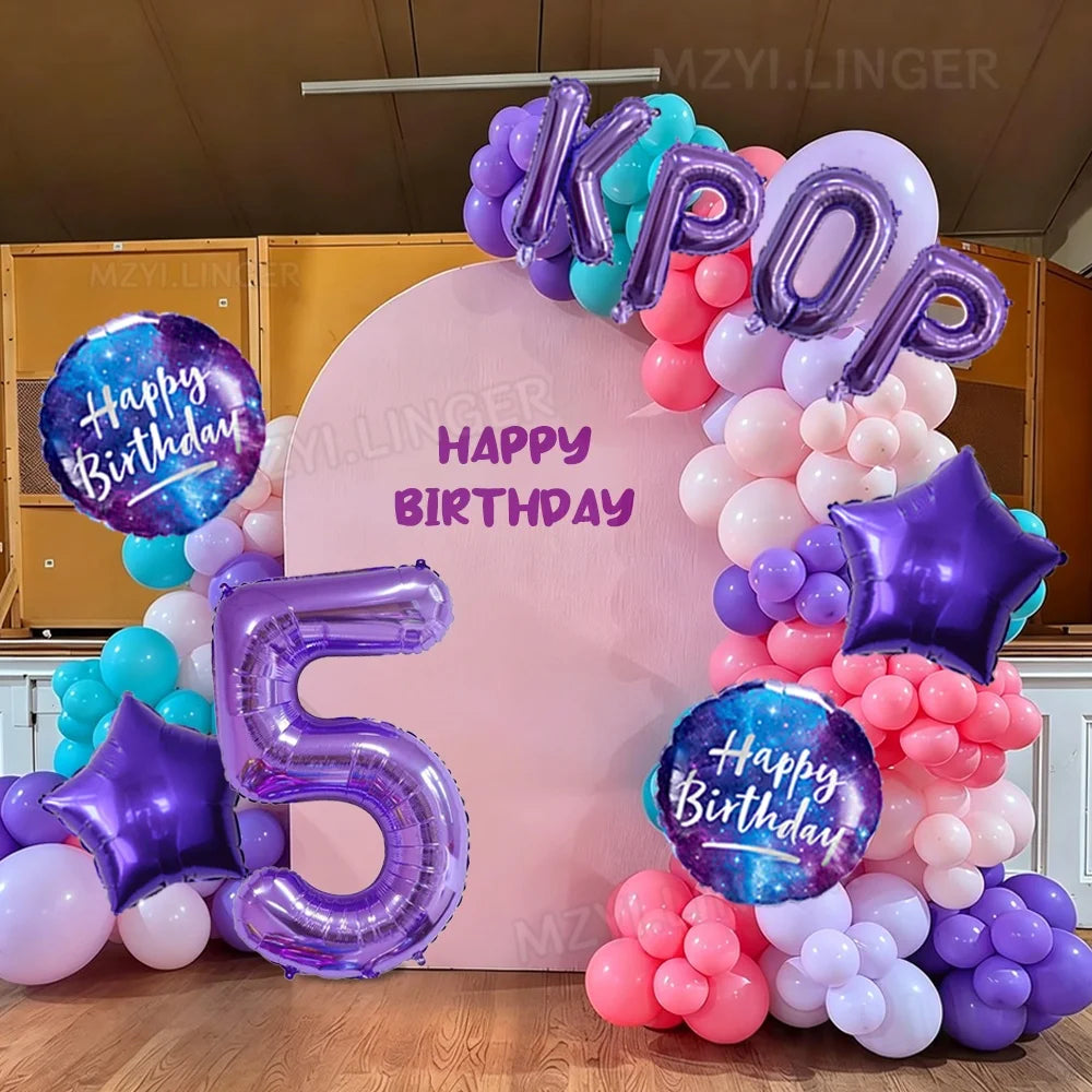 A large balloon arch featuring purple and blue foil numbers and round balloons for a birthday celebration.