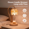 A brass flower candle warmer lamp with a lotus-shaped glass diffuser and wooden base on a bedside table.