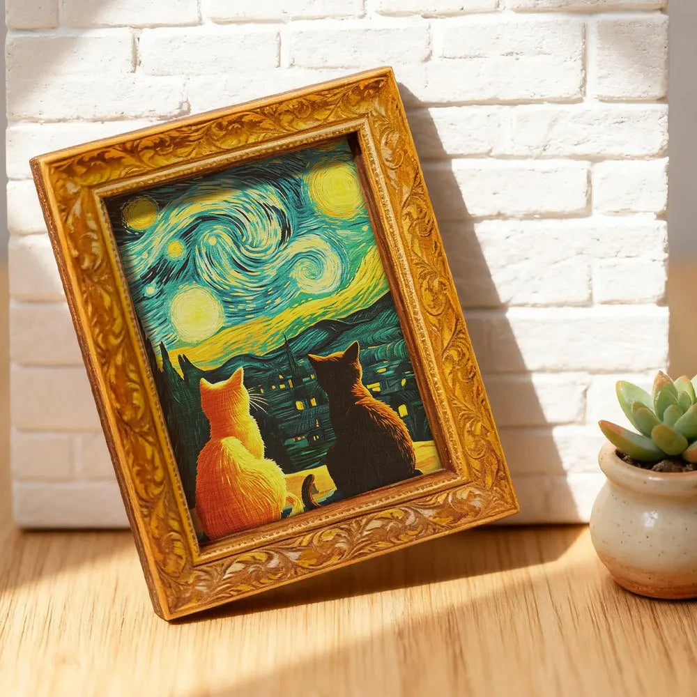 A framed print featuring a Van Gogh starry sky with cats, displayed on a wooden surface.