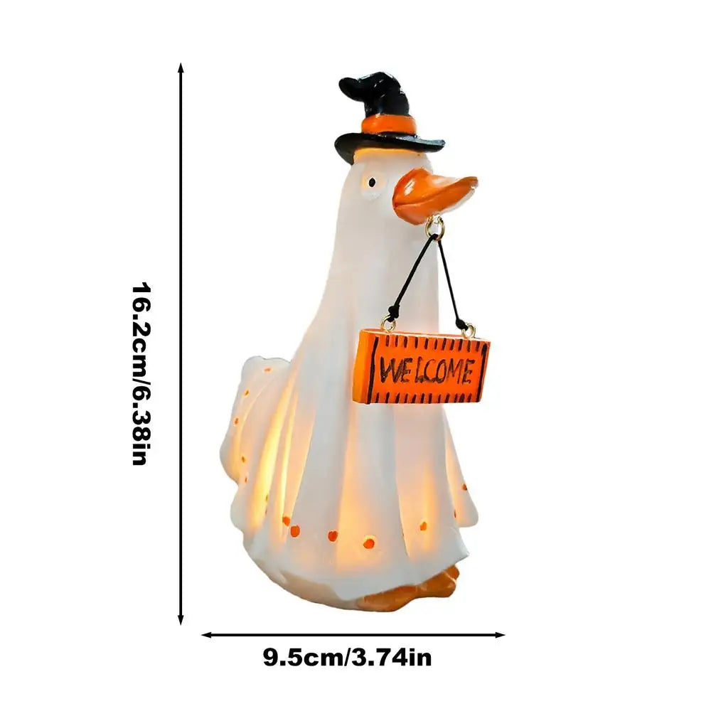 A white ghost figurine with a black hat and orange beak, illuminated for Halloween decor.