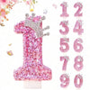 Pink sequin birthday number candles with a crown topper showing the numbers one through nine.