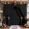 Elegant rectangular backdrop with black drapes adorned with red and white floral arrangements on the floor.