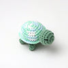 Handmade crocheted turtle plush toy in light green and pale blue colors.