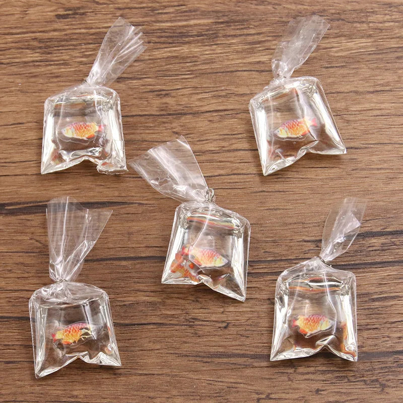 Un juego de imanes de pez payaso de resina transparente, empaquetados en pequeñas bolsas de plástico para hacer joyería