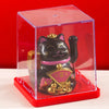 A black and gold waving lucky cat figurine displayed inside a clear red box.