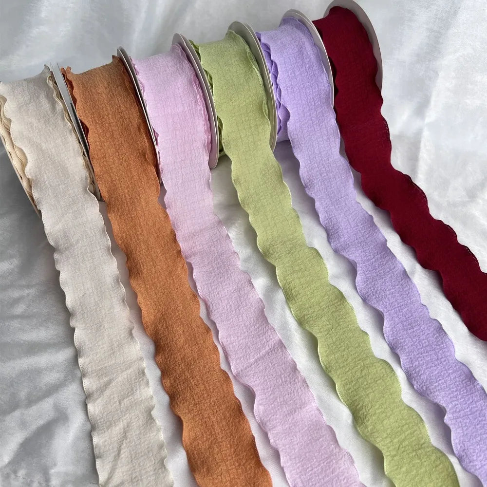 A collection of 10 yards of decorative fishtail yarn ribbon in various pastel and deep jewel tones.