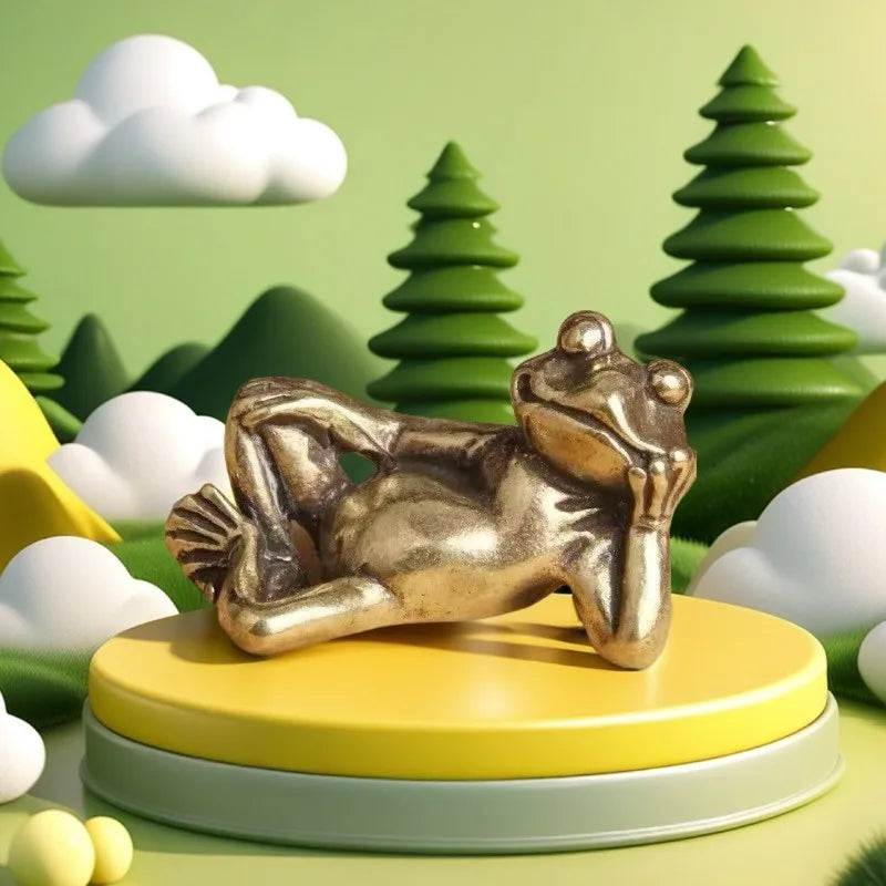 Antique brass sleeping frog figurine resting on a yellow circular base against a green landscape background