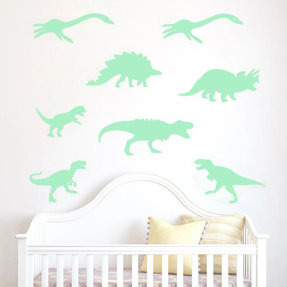 Wall decals of various green dinosaurs decorating a white crib