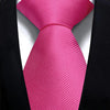 A vibrant pink silk necktie tied in a knot against a black suit jacket.
