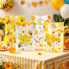Yellow and white honeycomb patterned gift bags with handles filled with honey for party favors