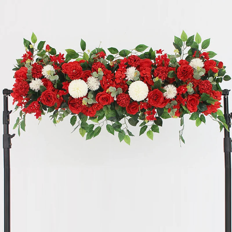 A lush floral arrangement of red and white roses and greenery for event decor.