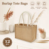 A beige burlap tote bag with cotton rope handles is displayed next to dried floral elements.